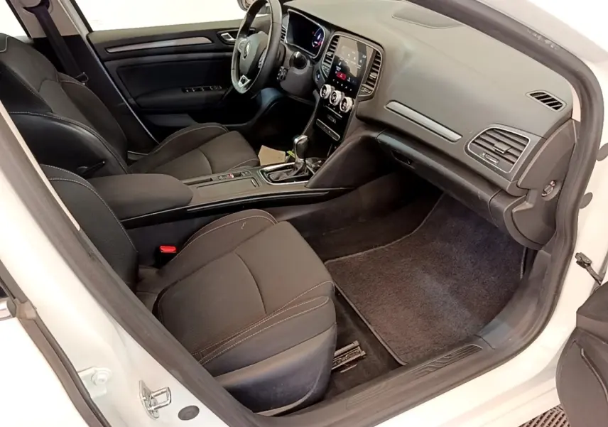 Intérieur côté passager d'une Renault Mégane Business E-Tech blanche, avec tableau de bord digital et sièges noirs.