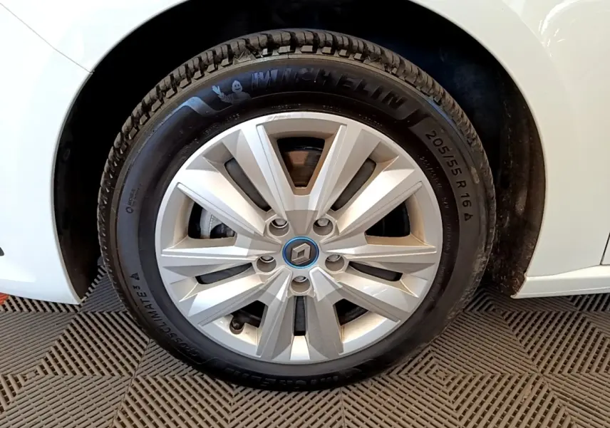Gros plan sur la roue avant gauche blanche d’une Renault Mégane Business E-Tech hybride rechargeable avec jante argentée.