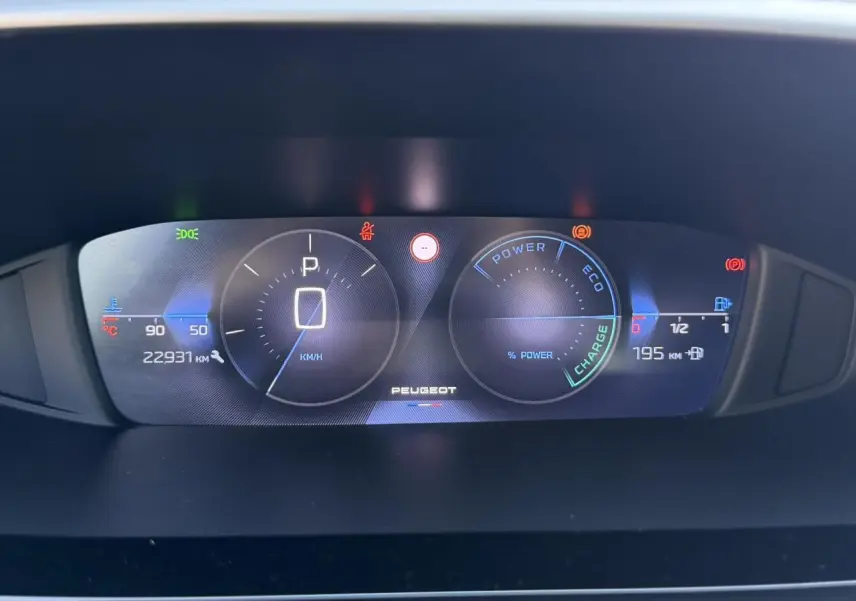 Vue rapprochée du combiné numérique 10 pouces de la Peugeot 308 Hybrid 2025 affichant vitesse, autonomie et indicateurs hybrides.