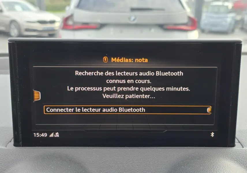Écran multimédia MMI de l'Audi Q2 35 TFSI 2023 affichant la recherche de lecteurs audio Bluetooth.