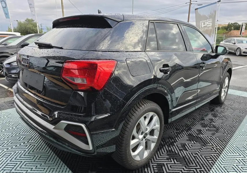 Audi Q2 noir mythic vue 3/4 arrière droit avec vitres surteintées et jantes aluminium 5 branches doubles.