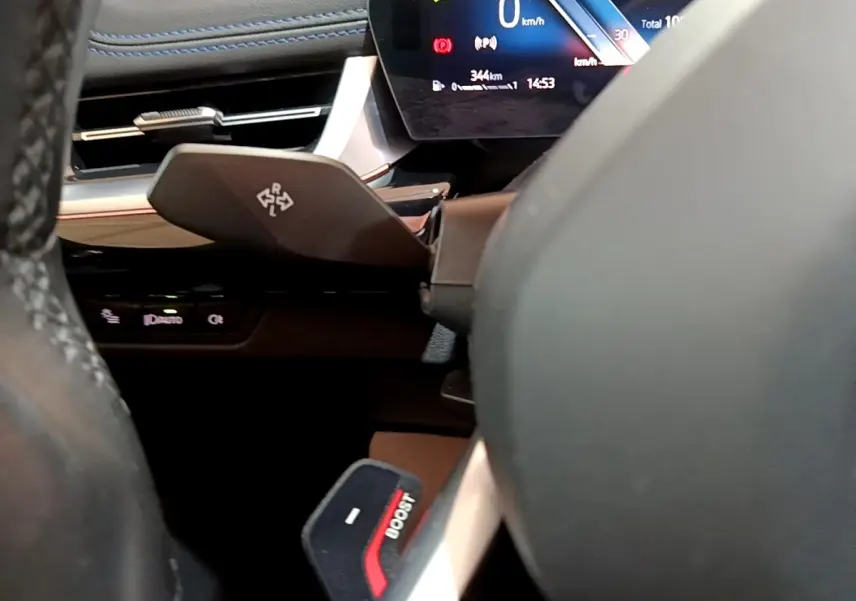 Gros plan sur le volant et le tableau de bord numérique du BMW X1 noir, affichant 0 km/h et indicateurs lumineux.