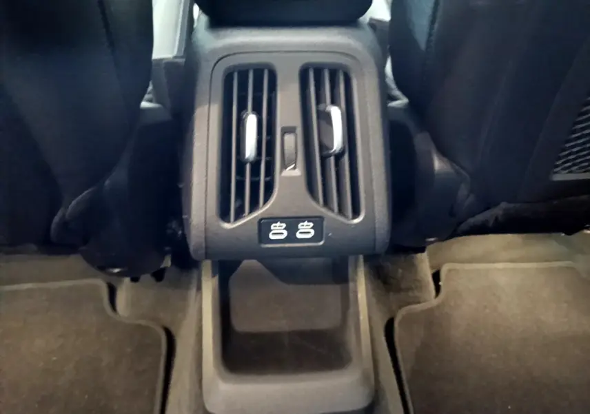 Vue rapprochée des aérateurs arrière et ports USB entre les sièges noirs du BMW X1 xDrive23i M Sport 2023.