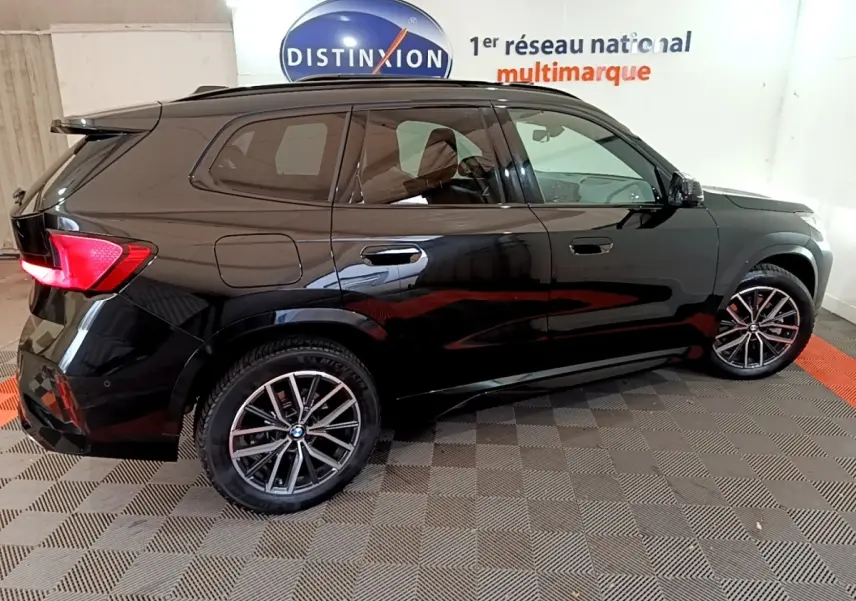 BMW X1 xDrive23i M Sport noir vue de profil côté droit, avec jantes alliage et vitres teintées.