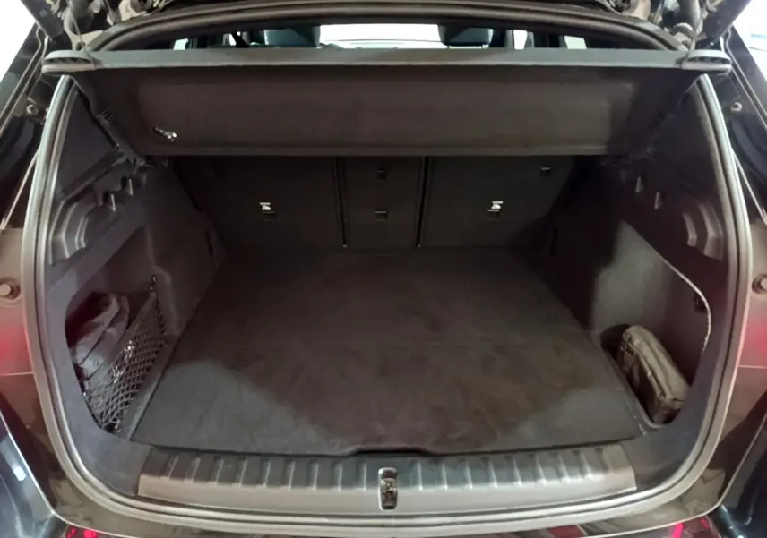 Coffre ouvert noir d'un BMW X1 xDrive23i M Sport 2023, montrant un espace de chargement propre et spacieux.