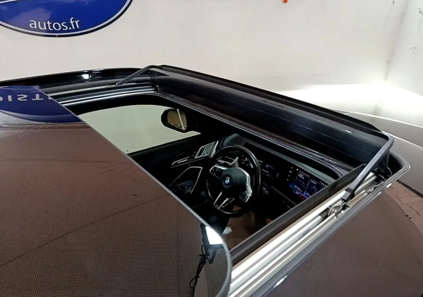 Vue plongeante sur l'intérieur noir du BMW X1 xDrive23i M Sport 2023 à travers son toit ouvrant panoramique.