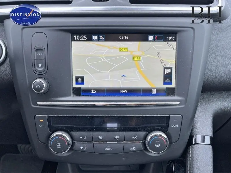 Vue rapprochée de l'écran tactile GPS et de la console centrale du Renault Kadjar 1.5 dCi gris platine, avec commandes climatisation.