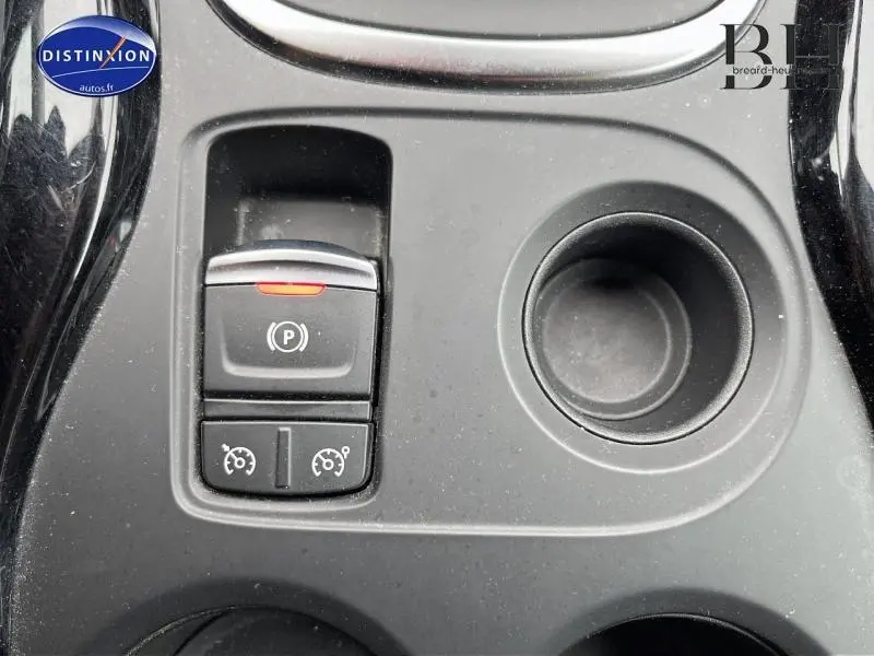Gros plan sur la console centrale noire du Renault Kadjar 1.5 dCi avec bouton de frein à main électrique et porte-gobelet.