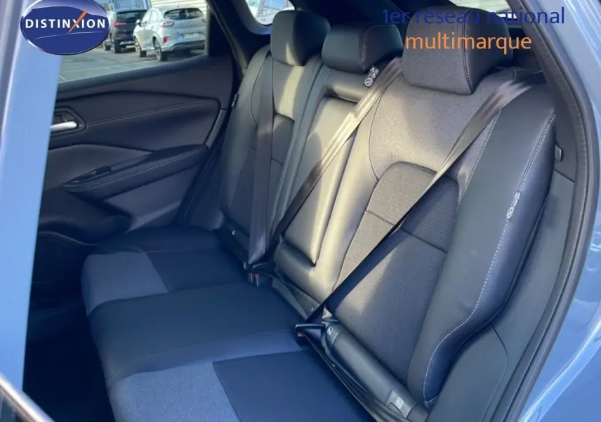 Vue intérieure montrant la banquette arrière en cuir et tissu noir du Nissan Qashqai 2025, porte arrière ouverte.