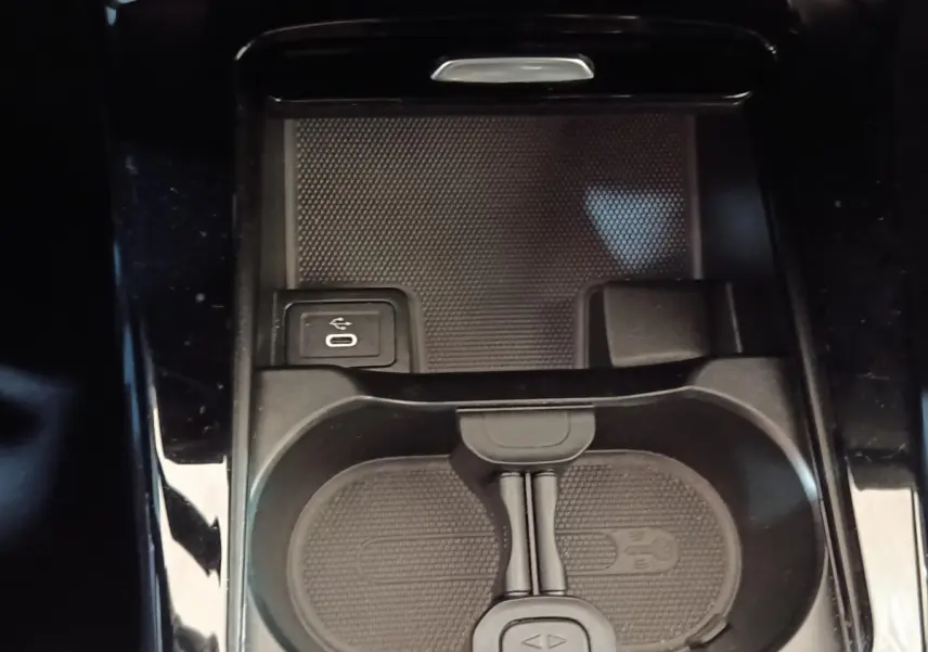 Gros plan sur la console centrale noire de la Mercedes Classe A 250 e avec prise USB et espace de rangement.