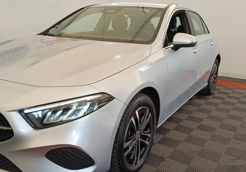 Vue 3/4 avant droit d'une Mercedes Classe A A 250 e Business Line gris clair avec phares LED et jantes noires.