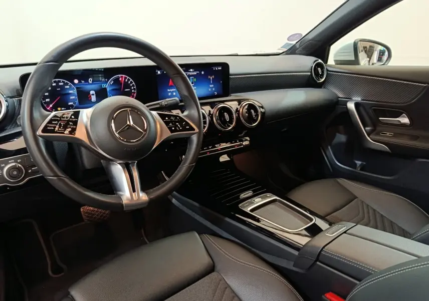 Vue intérieure côté conducteur de la Mercedes Classe A 250 e Business Line 2023, volant cuir alu et écran tactile double.