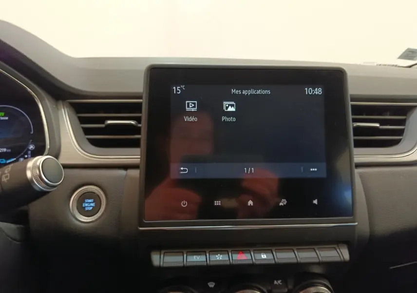 Vue intérieure centrée sur l'écran tactile et le tableau de bord du Renault Captur Intens E-TECH gris clair 2021.