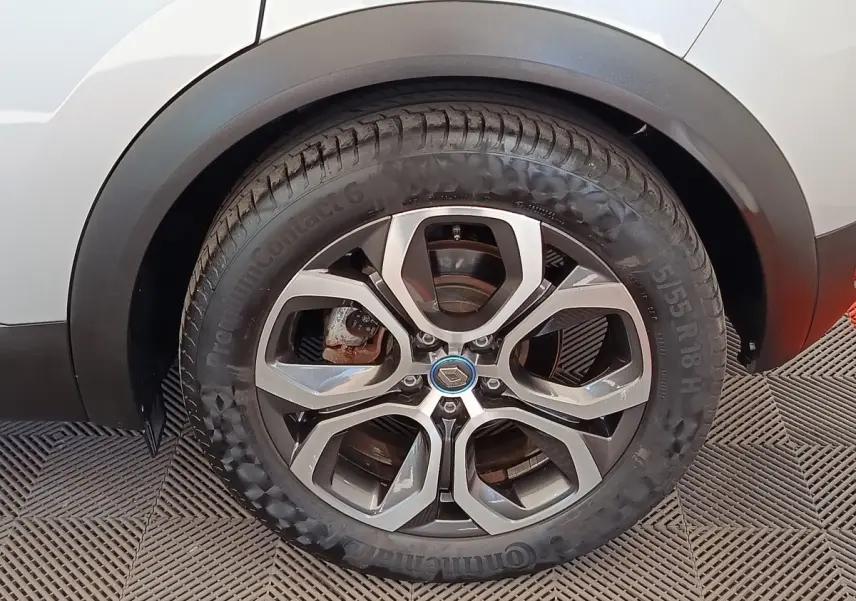 Gros plan sur la roue arrière droite d’un Renault Captur gris clair, jante alliage à cinq branches doubles.