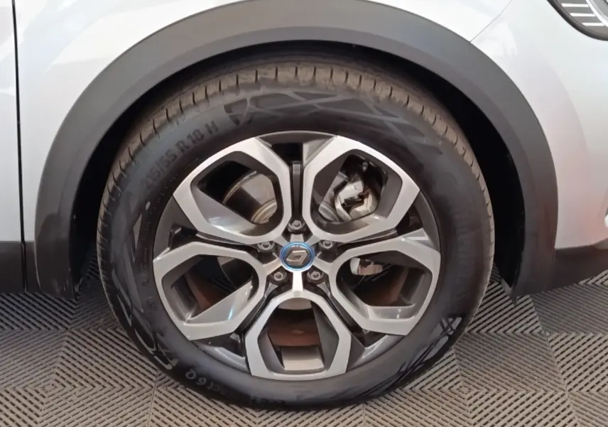 Gros plan sur la roue avant droite du Renault Captur gris clair, mettant en valeur la jante alliage au design moderne.