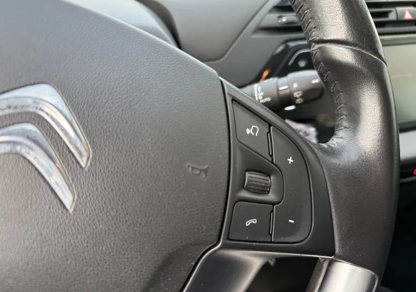 Gros plan sur le volant en cuir noir du Citroën Grand C4 Spacetourer 2019 avec commandes audio intégrées.