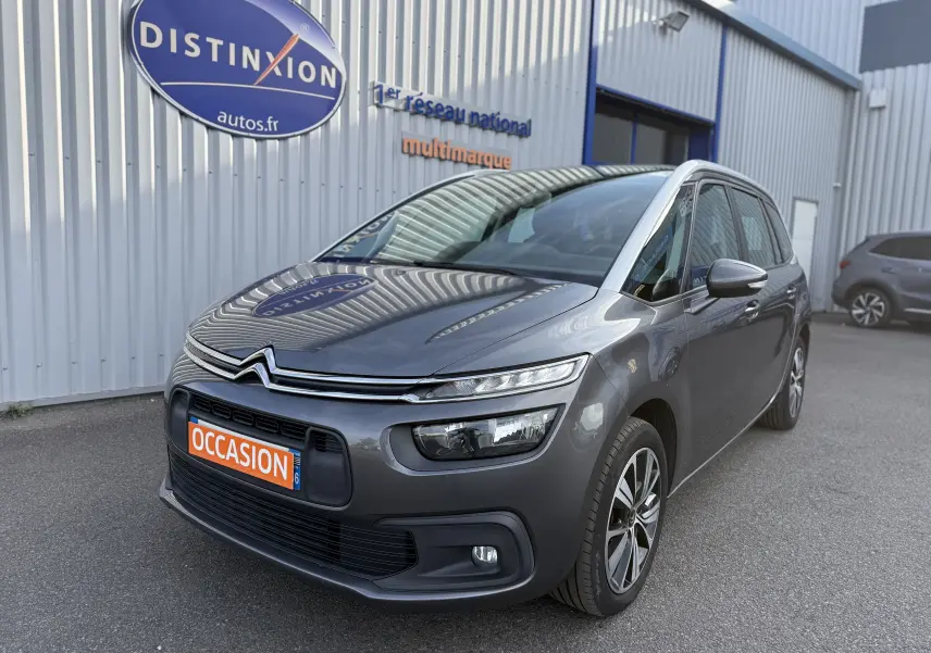Citroën Grand C4 Spacetourer gris en 3/4 avant droit, avec attelage visible et plaque "OCCASION" orange.