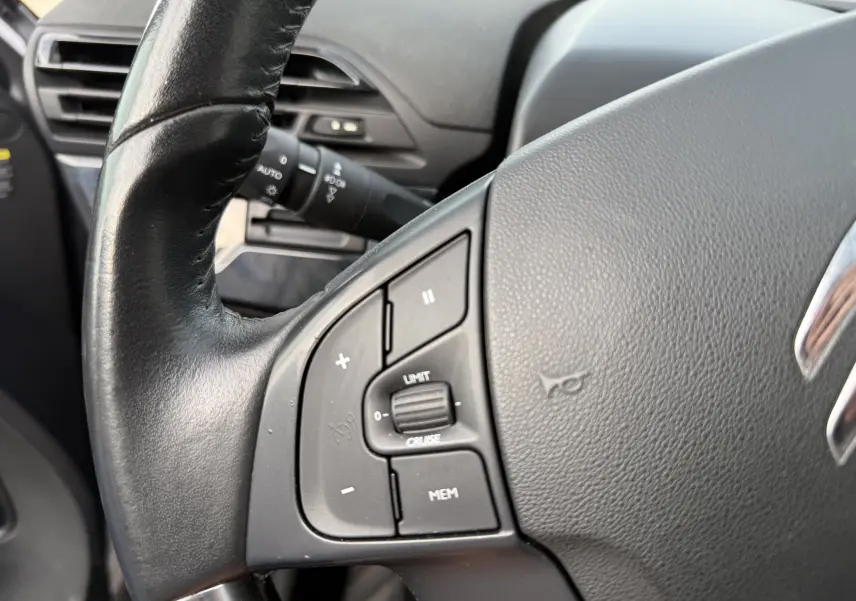 Gros plan sur le volant noir du Citroën Grand C4 Spacetourer 2019, montrant les commandes de régulateur de vitesse.