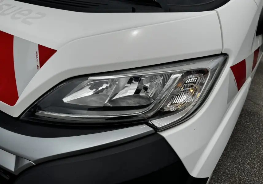 Gros plan sur le phare avant droit blanc du Citroën Jumper 2019 avec marquages rouges sur la carrosserie.