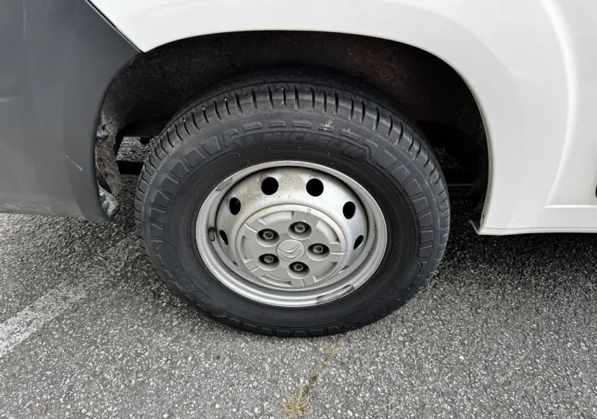 Gros plan sur la roue avant droite en jante acier du Citroën Jumper blanc, avec pneu Michelin visible.