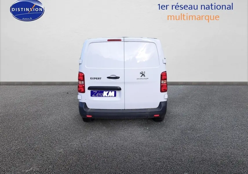 Vue arrière d'un Peugeot Expert Cabine Approfondie blanc Kaolin, avec portes battantes fermées sur un sol goudronné.
