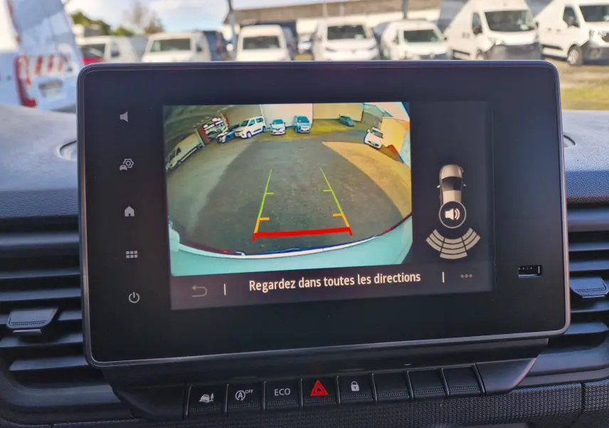 Écran tactile intérieur montrant la caméra de recul du Renault Trafic blanc, vue arrière avec guidage coloré.