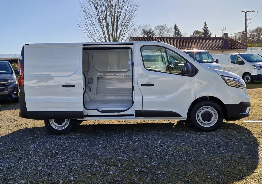 Vue de profil côté droit du Renault Trafic Fourgon blanc 2025 avec porte latérale coulissante ouverte montrant l'intérieur vide.