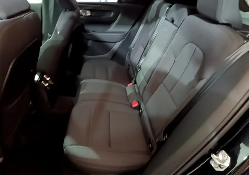 Vue intérieure côté droit des sièges arrière noirs du Volvo XC40 Recharge T4 Business 2020 avec ceintures visibles.