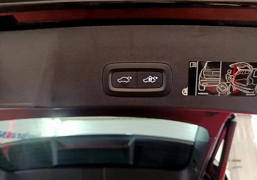 Boutons de commande d'ouverture et verrouillage du coffre sur la partie intérieure du hayon d'un Volvo XC40 noir.
