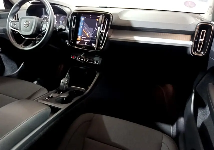 Intérieur noir du Volvo XC40 Recharge T4 vu côté conducteur, avec écran tactile central et volant multifonctions.