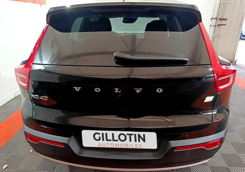 Vue arrière d'un Volvo XC40 noir avec feux arrière en forme de C et logo VOLVO bien visible sur le hayon.
