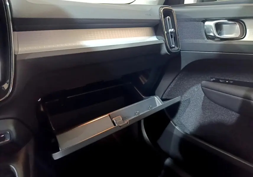 Vue intérieure côté passager du tableau de bord noir et boîte à gants ouverte du Volvo XC40 Recharge T4 2020.