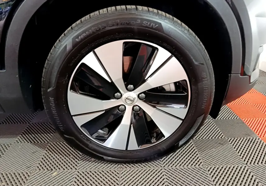 Gros plan sur la roue avant droite noire et argentée du Volvo XC40 Recharge T4 211 DCT7 Business noir.