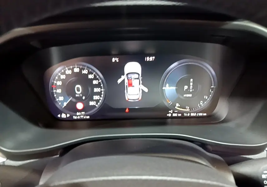 Tableau de bord numérique du Volvo XC40 Recharge T4 noir, affichant vitesse, autonomie et portes ouvertes.