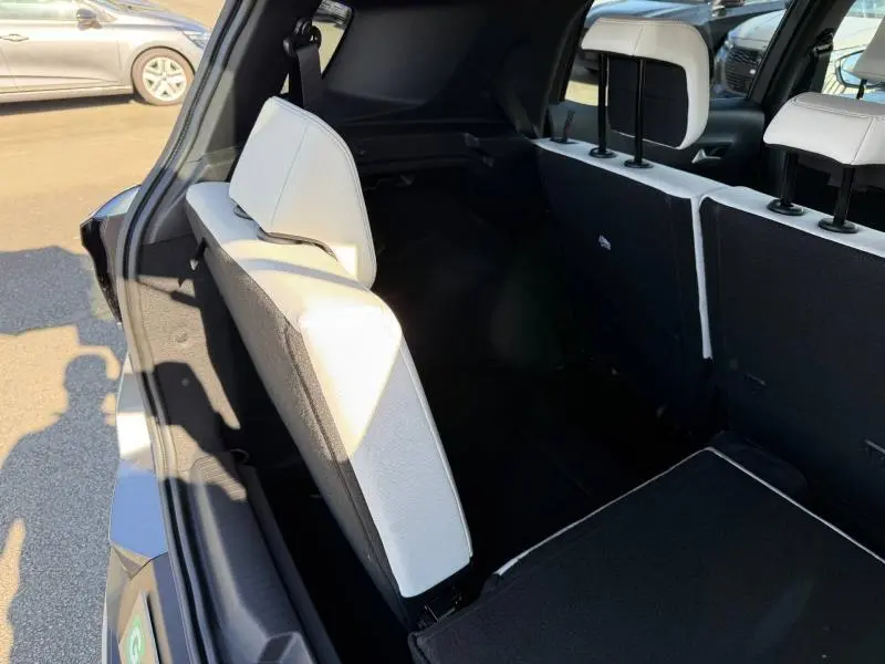 Vue arrière droite du coffre du Citroën C3 Aircross gris Mercury avec sièges arrière blancs partiellement rabattus.