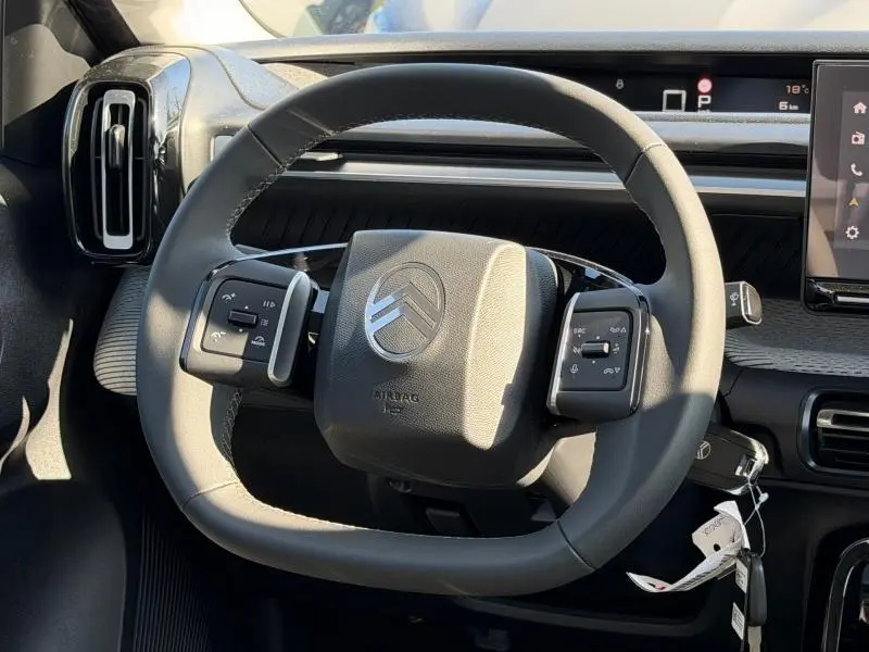 Vue rapprochée du volant multifonction noir de la Citroën C3 Aircross 2026 avec tableau de bord et écran tactile.