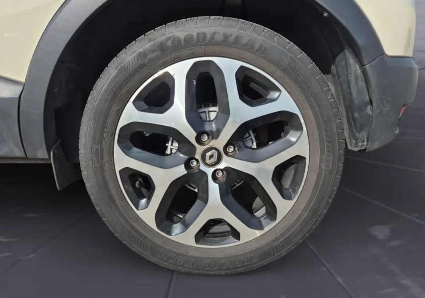 Gros plan sur la roue avant droite beige/marron d'un Renault Captur 2018 avec jante alliage à motifs noirs et argentés.