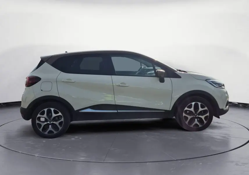 Renault Captur beige/marron vue de profil côté gauche, avec jantes alliage et toit noir contrasté.