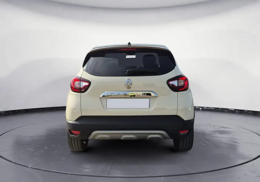 Vue arrière d'un Renault Captur beige/marron 2018 avec feux rouges et lunette arrière teintée.
