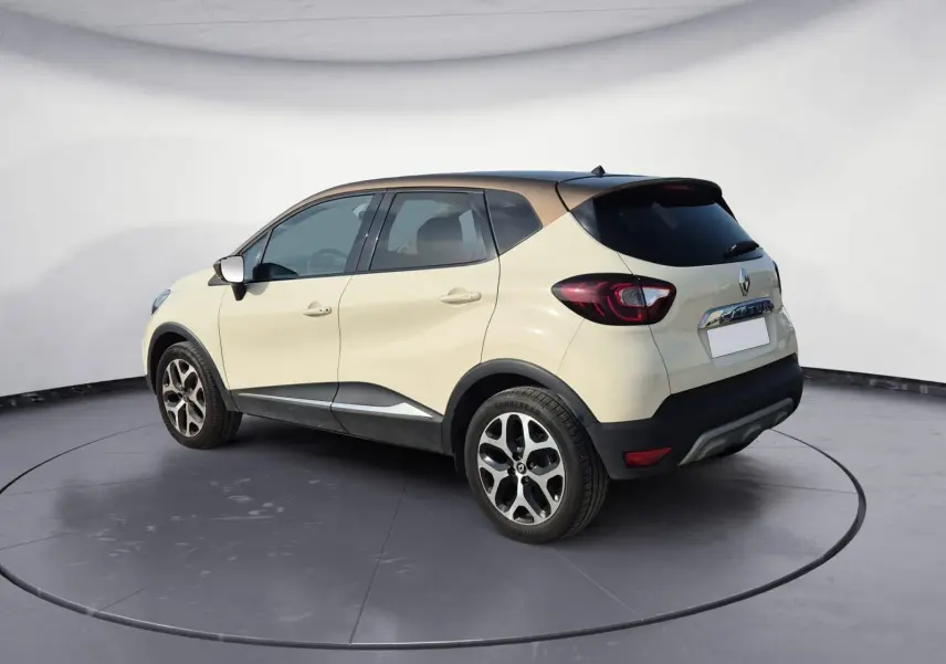 Renault Captur beige et marron en vue 3/4 arrière droit, avec jantes alliage et toit foncé contrastant.