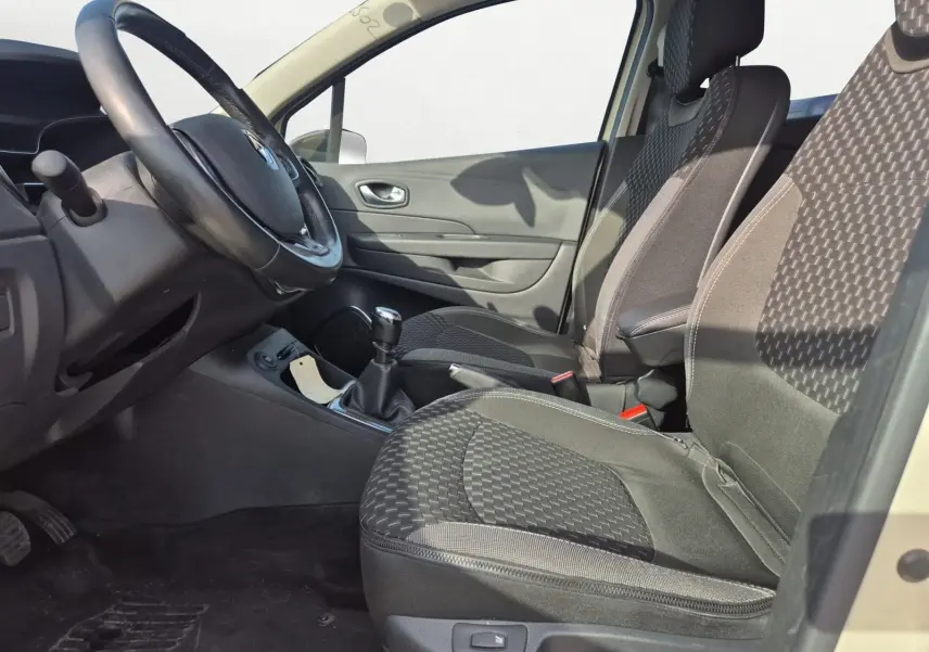 Vue intérieure côté gauche du Renault Captur 2018, sièges tissu noir à motifs, volant cuir et levier de vitesse manuel.