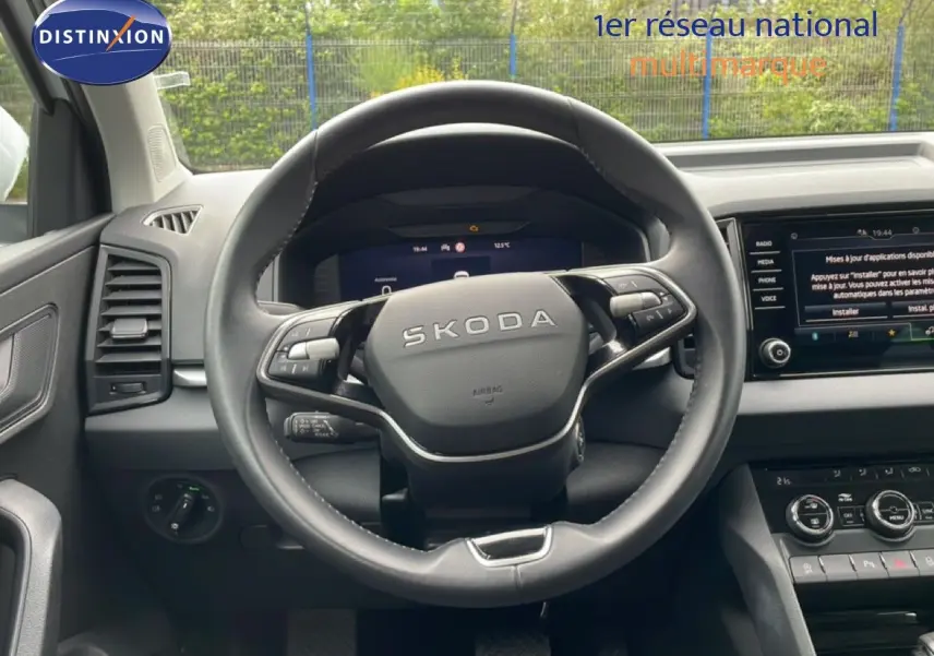 Vue intérieure centrée sur le volant noir SKODA du Karoq 2025, avec tableau de bord numérique et écran tactile visible.