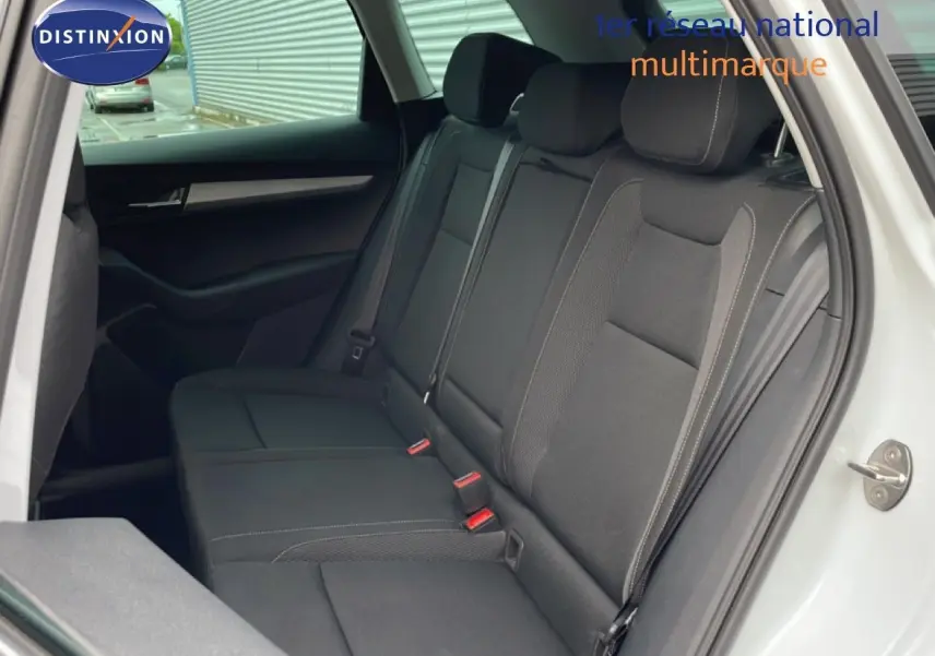 Vue intérieure côté gauche des sièges arrière noirs en tissu du Skoda Karoq blanc glacier 2025, porte ouverte.