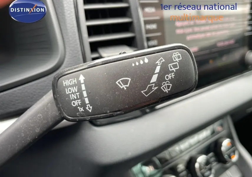 Gros plan sur la commande d’essuie-glace noire à gauche du volant dans l’habitacle du Skoda Karoq blanc glacier 2025.