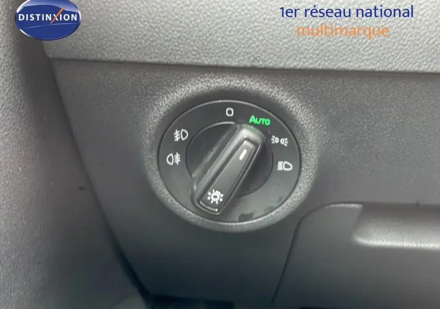 Gros plan sur la molette de réglage des phares du Skoda Karoq blanc glacier, intérieur noir.