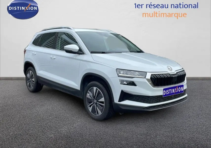 Vue 3/4 avant gauche d'un Skoda Karoq blanc glacier avec calandre noire et jantes bi-ton.