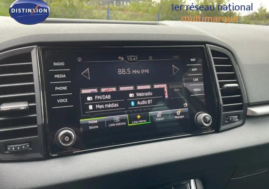 Vue rapprochée de l’écran tactile central du Skoda Karoq blanc glacier 2025 avec interface multimédia affichée.
