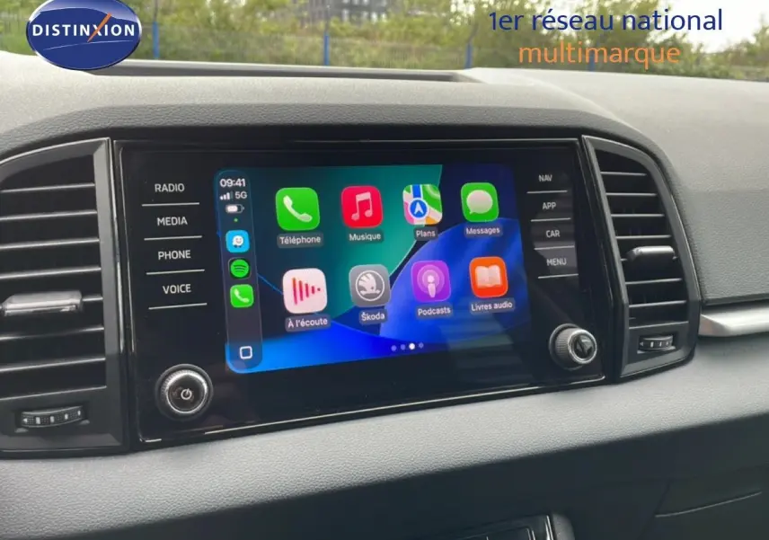 Écran tactile central du tableau de bord du Skoda Karoq blanc glacier, affichant Apple CarPlay.