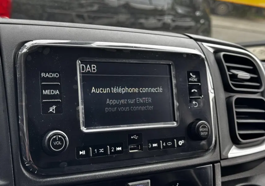 Gros plan sur l’écran tactile central du tableau de bord du Peugeot Boxer Fourgon blanc, affichant un message de connexion téléphone.