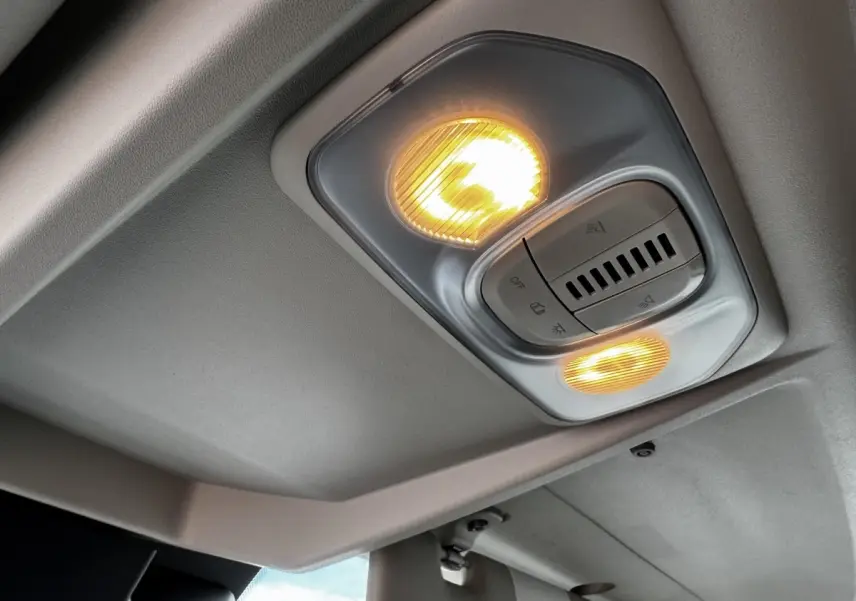 Plafonnier intérieur allumé avec commandes d’éclairage, vue du plafond du Peugeot Boxer Fourgon blanc L2H1.